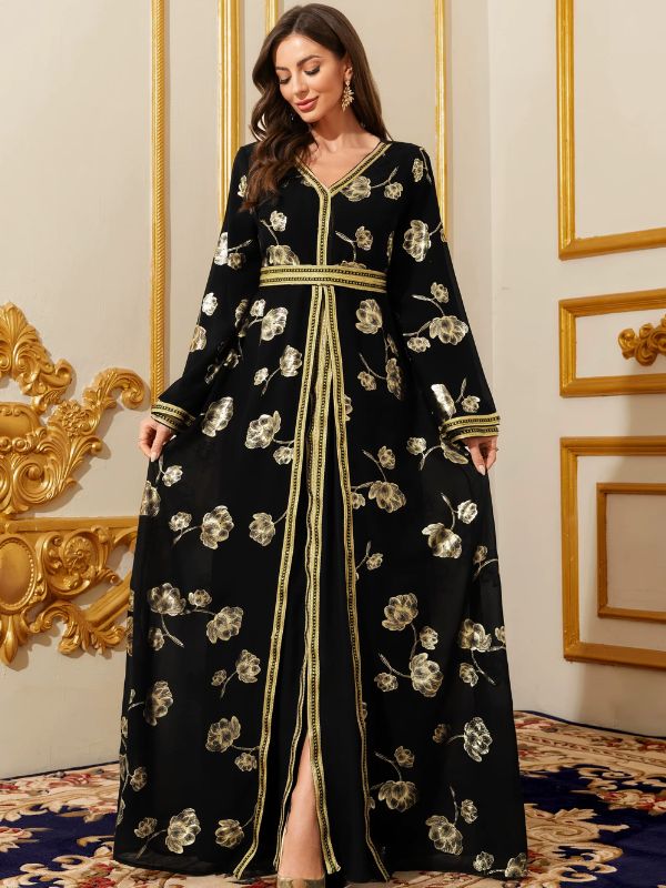 Caftan noir à motifs floraux dorés et ceinture brodée, regard baissé, pose de trois quarts