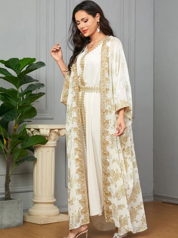 Une femme marche doucement en caftan blanc à ceinture dorée