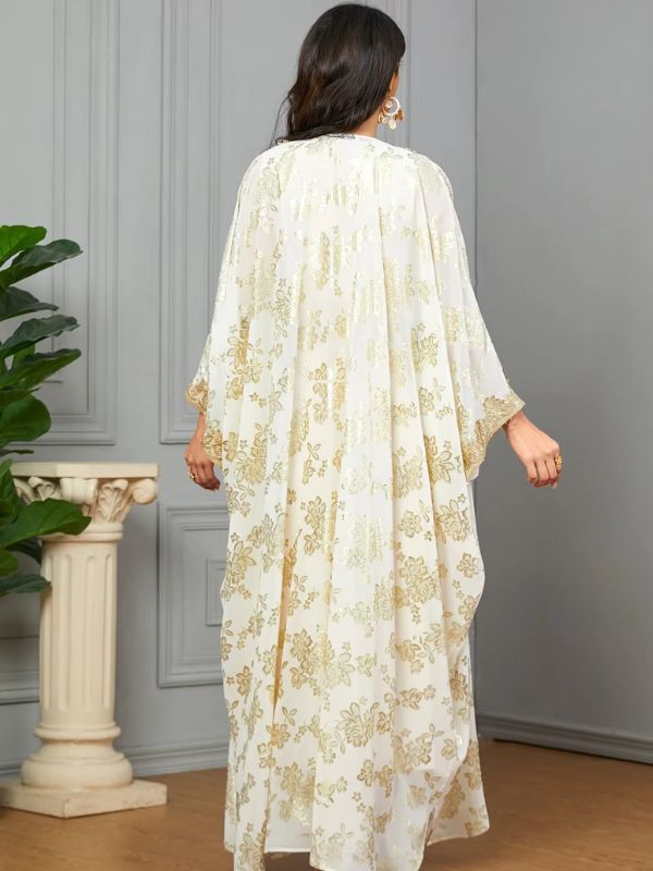 Une femme vue de dos en caftan blanc à motifs dorés