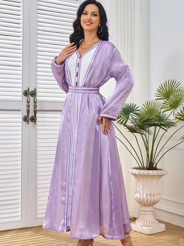 Femme souriante en caftan marocain lila et blanc à boutons décoratifs