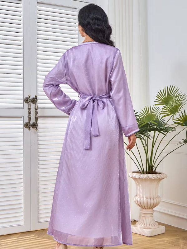 Une femme de dos porte un caftan marocain lila satiné noué à la taille