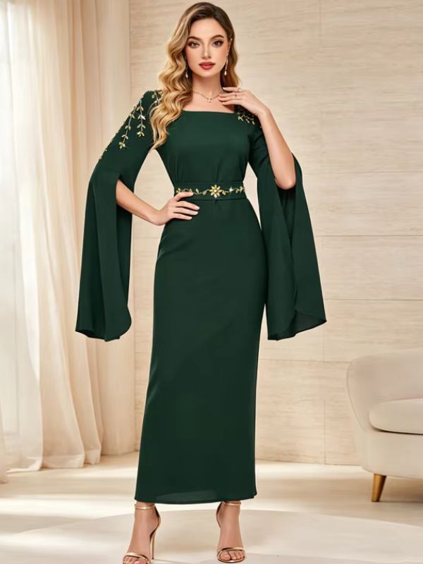 Femme portant un caftan longue vert émeraude ajustée à manches évasées et col carré, debout de face