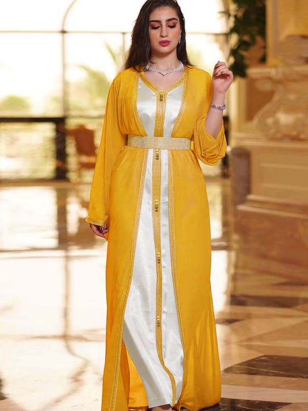 Femme portant un caftan marocain jaune et blanc avec ceinture brillante