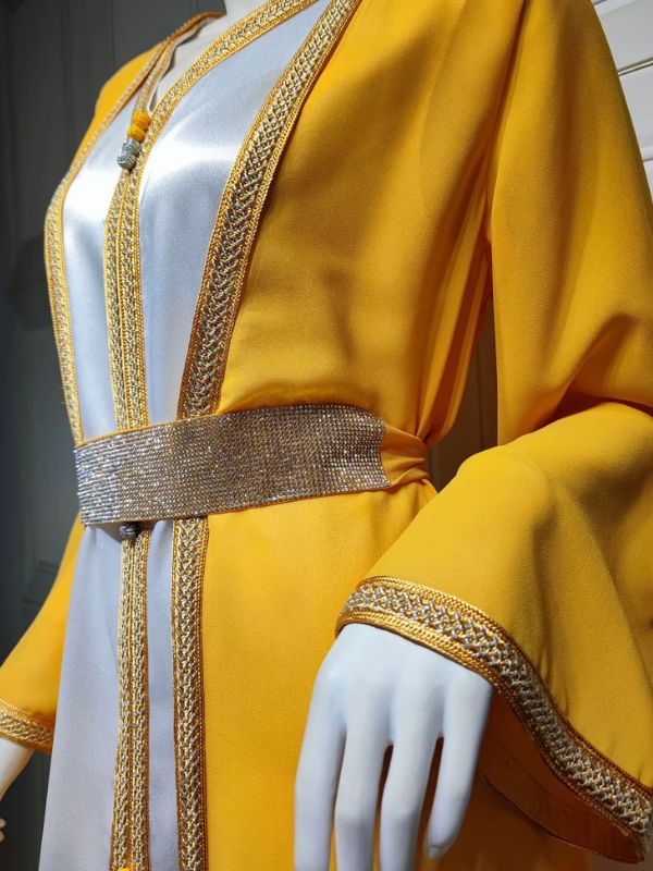 Zoom sur le haut d’un caftan marocain jaune à broderies dorées