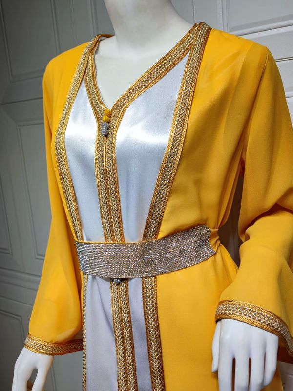 Femme portant un caftan marocain jaune et blanc avec ceinture brillante