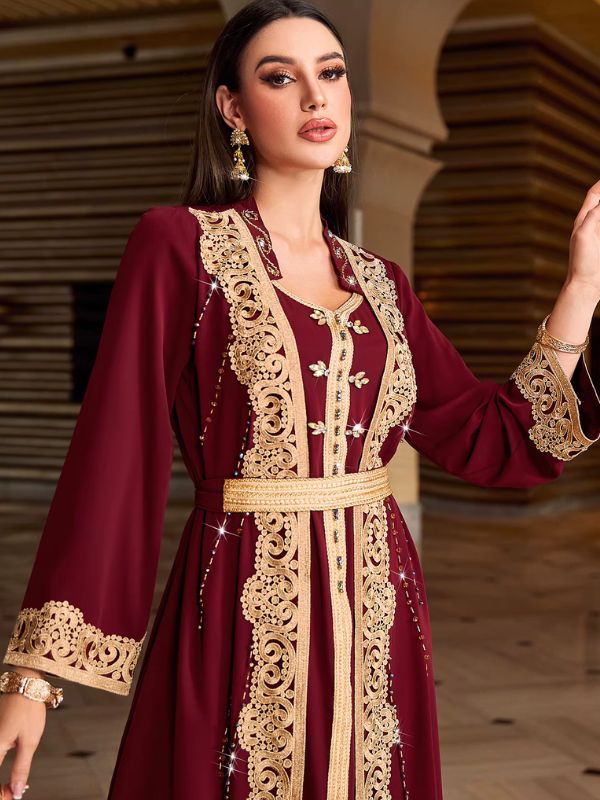 Détail d'un caftan bordeaux à boutons aakad dorés et broderie ajourée sur plastron et ceinture