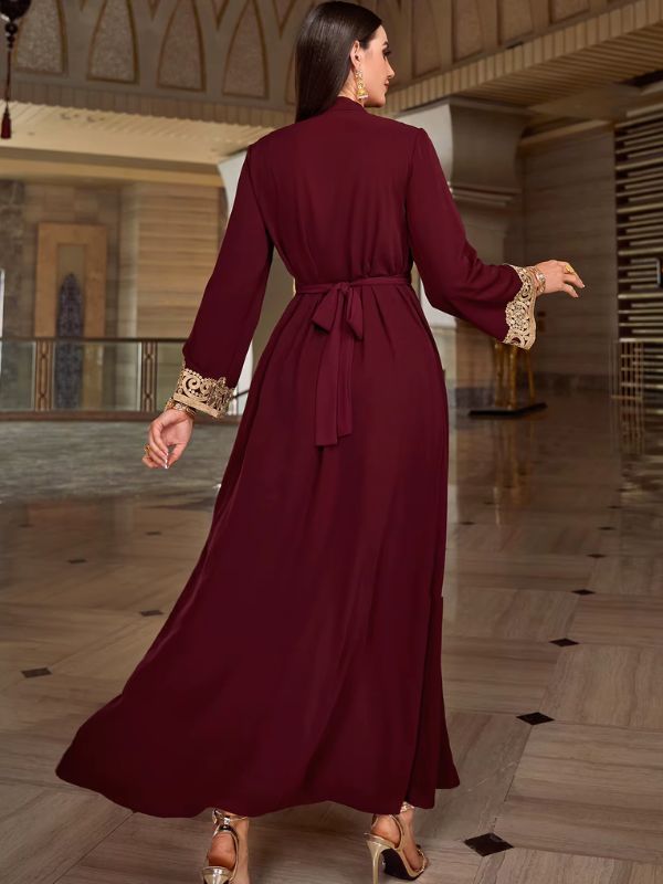 Caftan bordeaux à manchettes brodées dorées, vue de dos avec ceinture nouée, hall en marbre