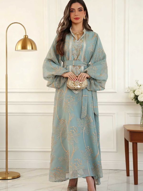 Caftan marocain mariage bleu céladon porté, mains sur la pochette, plastron brodé et jupe à motifs dorés