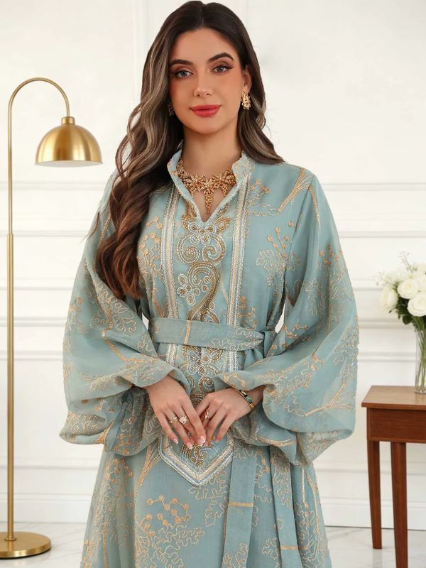 Gros plan sur le col montant en V, le plastron brodé et la ceinture du caftan marocain mariage bleu céladon