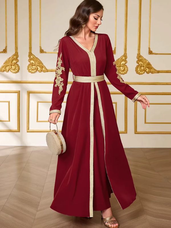 Caftan bordeaux Rubis de Marrakech en marche, pans avant bordés de galon doré qui s'entrouvrent sur la jupe