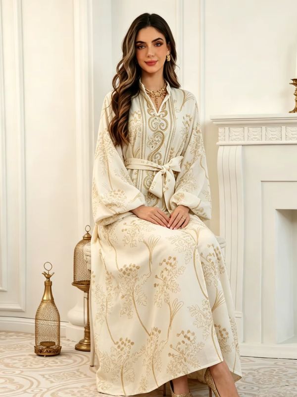 Femme assise portant le caftan marocain mariage crème aux broderies dorées, mains sur les genoux