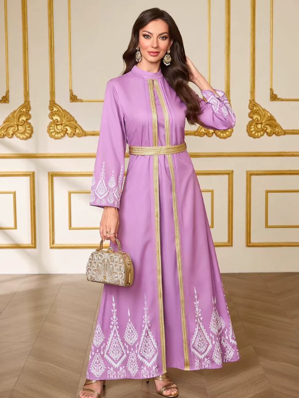 Caftan lilas Aube de Tanger en pied, jupe longue et évasée jusqu'aux chevilles, pochette dorée en mise en scène
