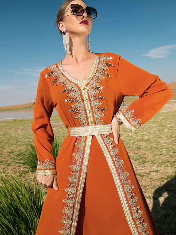 Caftan marocain mariage orange, main sur la hanche, poignets brodés et galon doré au décolleté