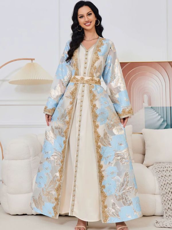 Caftan marocain mariage prestige bleu ciel porté, mains sur le manteau ouvert laissant voir la robe intérieure crème