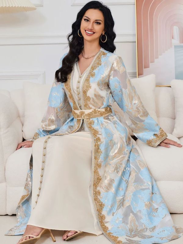 Femme assise portant le caftan marocain mariage prestige bleu ciel, pans du manteau étalés sur la robe crème