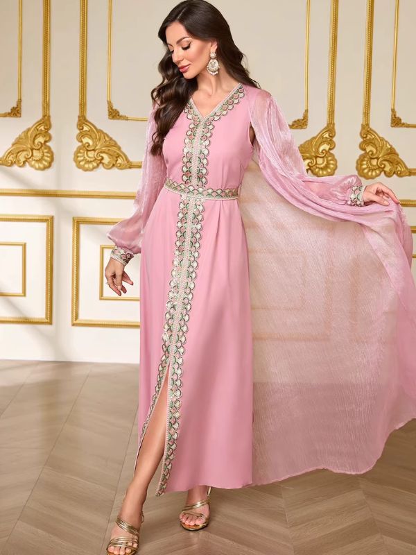 Caftan rose Nacre de Tétouan de trois quarts, voile du surcaftan flottant et fente centrale de la robe soulignée par le galon brodé