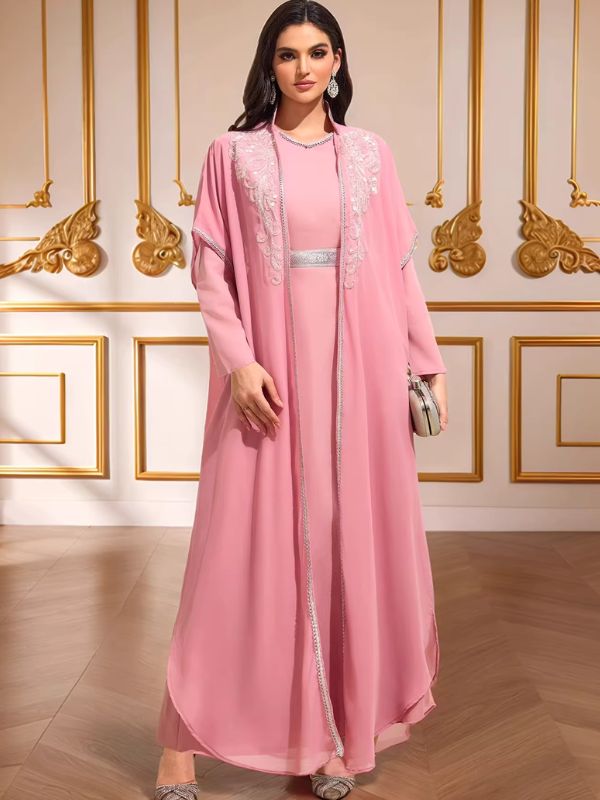 Caftan marocain mariage rose Pétale de Meknès en pied, surcaftan ouvert bordé de strass, pochette en mise en scène