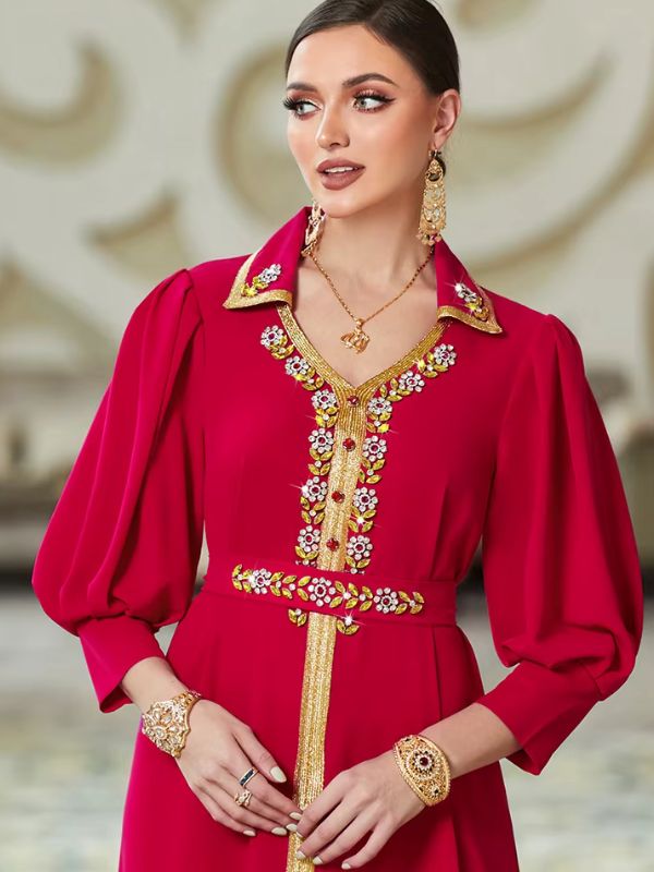 Détail du col chemise doré, du décolleté en V orné de fleurs en strass et de la ceinture assortie du caftan marocain mariage rouge