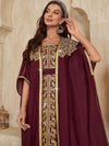 Caftan marocain bordeaux brodé de doré, porté par une femme