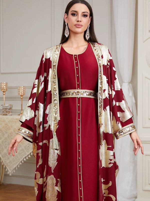 Femme brune portant un caftan marocain bordeaux orné de sequins dorés, vue rapprochée de face