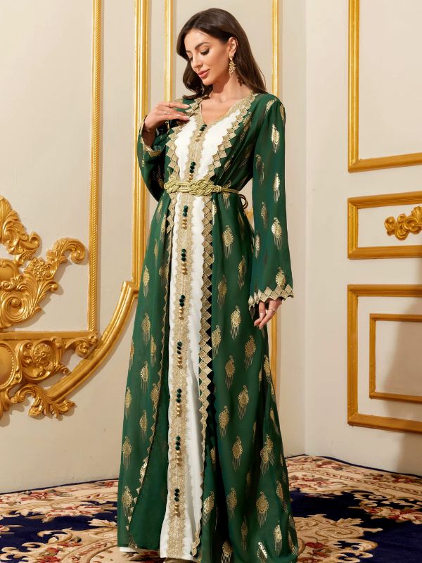 Femme portant un caftan marocain vert émeraude et blanc à galons dorés, vue de trois quarts