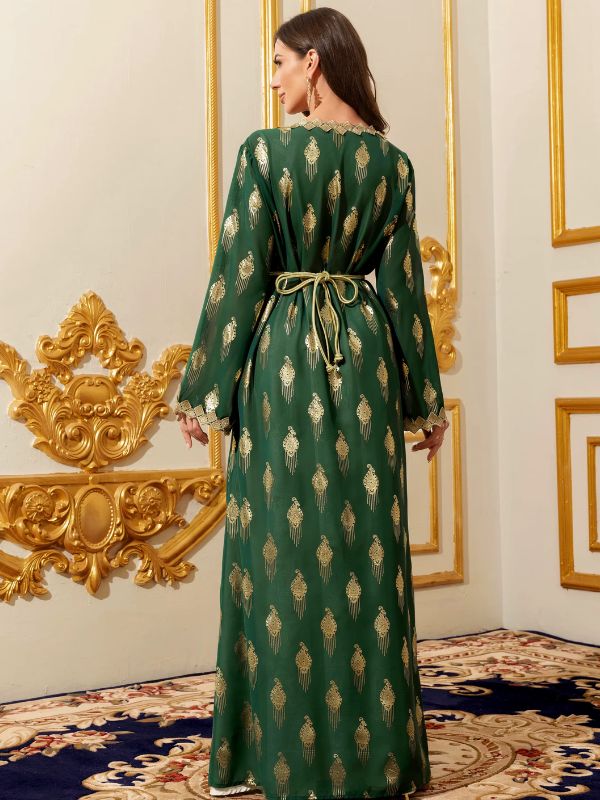 Femme de dos portant un caftan marocain vert émeraude à motifs dorés avec ceinture nouée