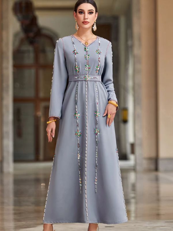 Femme portant un caftan marocain gris perle à fleurs perlées multicolores, col en V, debout de face