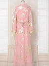 Vue arrière d’un caftan marocain rose orné de motifs dorés, ceinturé à la taille