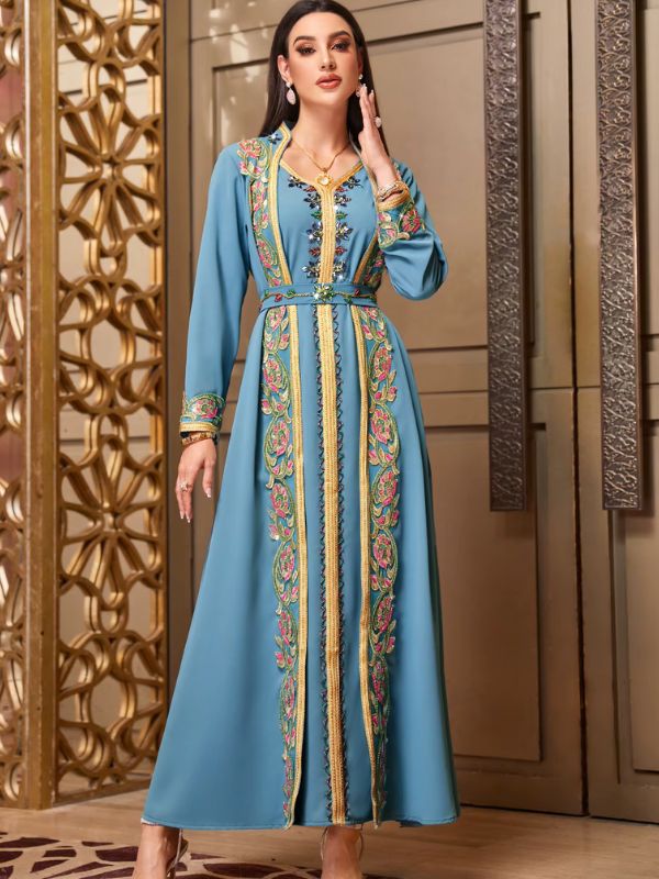 Femme portant un caftan marocain turquoise à broderies florales multicolores et galon doré, col en V, ceinture assortie