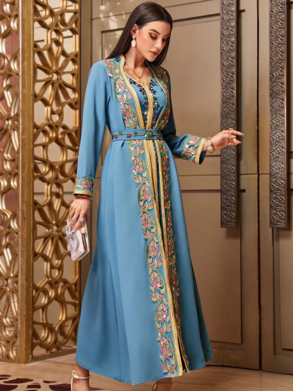 Femme de profil avec un petit sac portant un caftan marocain turquoise à broderies florales multicolores