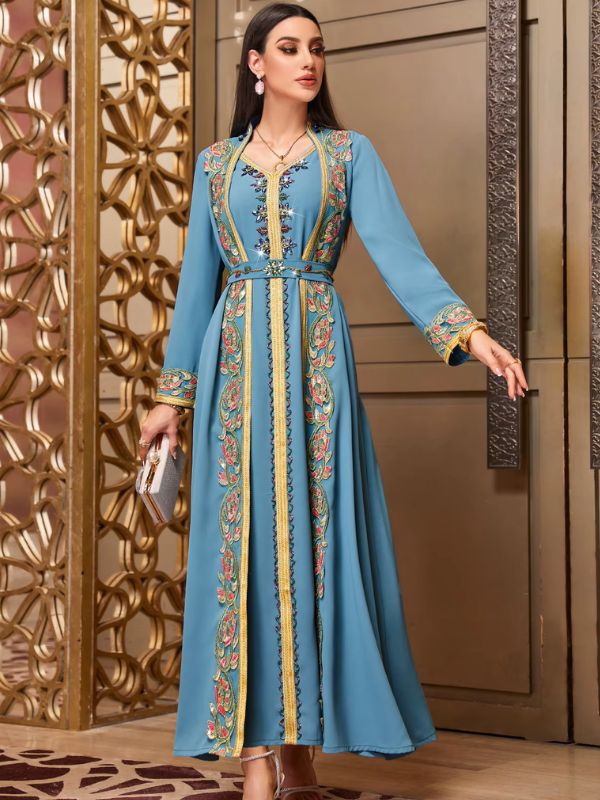 Femme portant un caftan marocain turquoise dans un intérieur luxueux
