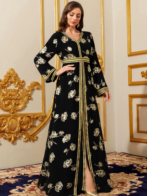 Femme portant un caftan marocain noir aux motifs floraux dorés et bordures galonnées, dans un salon somptueux