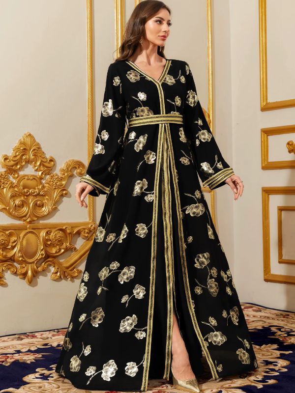 Femme portant un caftan marocain noir à fleurs dorées, fente centrale et fines bordures dorées, avec des escarpins assortis