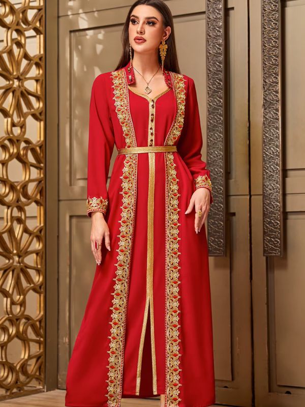 Femme portant un caftan marocain rouge à broderies dorées médaillons et col en V, debout de face