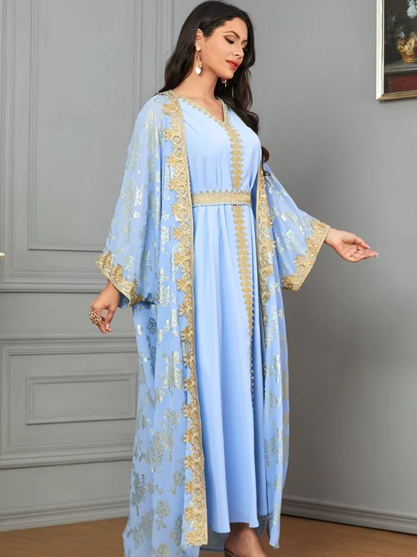 Une femme en caftan bleu regarde vers le sol avec élégance
