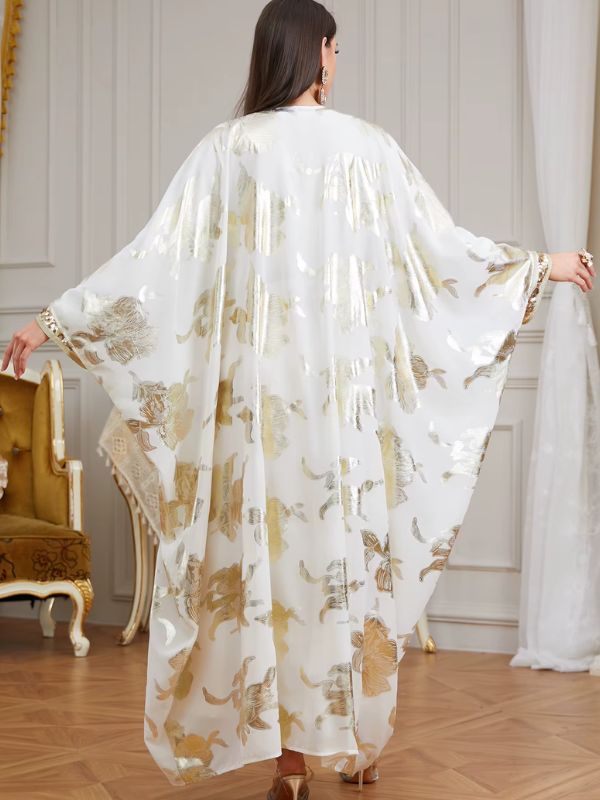 Femme de dos portant un caftan marocain blanc à motifs floraux dorés aux manches amples