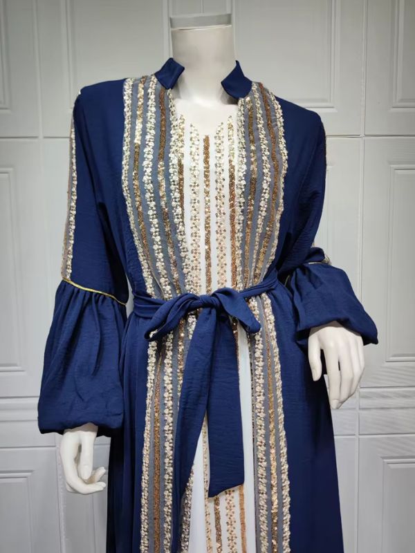 Caftan bleu royal à sequins dorés et blancs, ceinture nouée à la taille, vue rapprochée sur mannequin.
