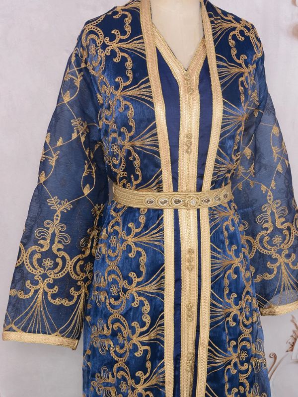 Mannequin habillé d’un caftan marocain bleu sombre aux détails argentés se tenant debout avec allure