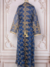 Mannequin en caftan marocain bleu foncé brodé d’argent marchant doucement dans un cadre raffiné