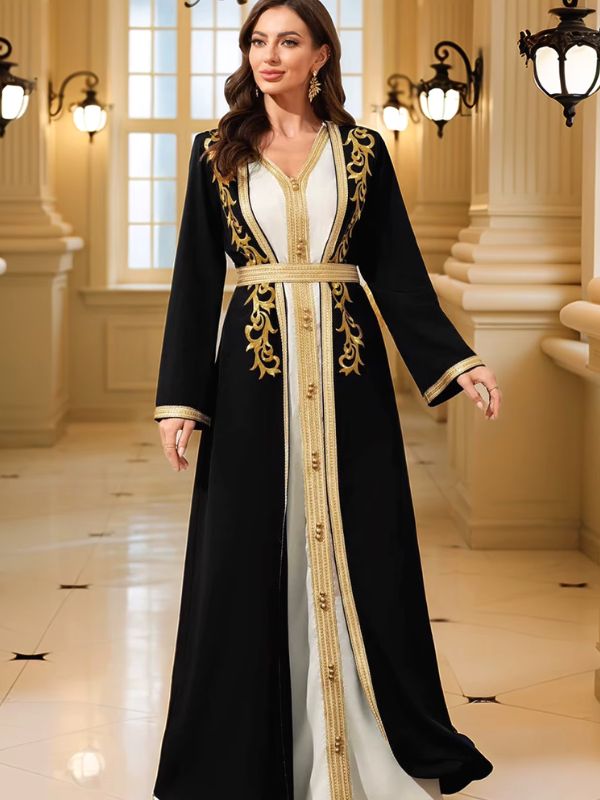 Femme souriante portant un caftan marocain noir et blanc à galons dorés, main sur la hanche