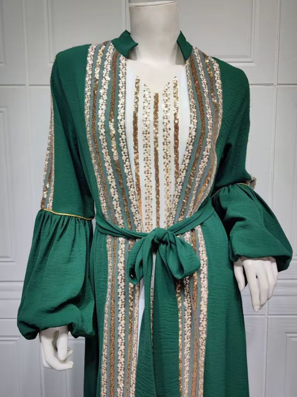 Caftan vert émeraude à sequins dorés et blancs, ceinture nouée à la taille, vue rapprochée sur mannequin.
