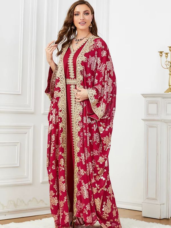 Une femme pose en caftan bordeaux ceinturé à motifs dorés