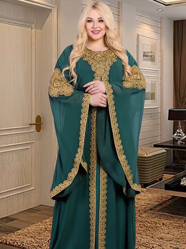 Une femme porte un caftan vert émeraude avec des broderies dorées