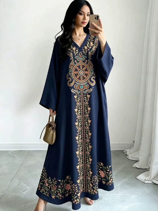 Femme en djellaba bleu nuit à broderies florales multicolores et médaillon oriental
