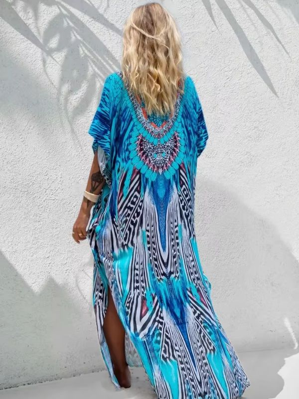 Une femme porte une djellaba longue aux motifs turquoises et orientaux, vue de dos sous une lumière estivale