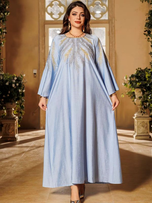 Une femme porte une djellaba bleu clair avec des broderies dorées