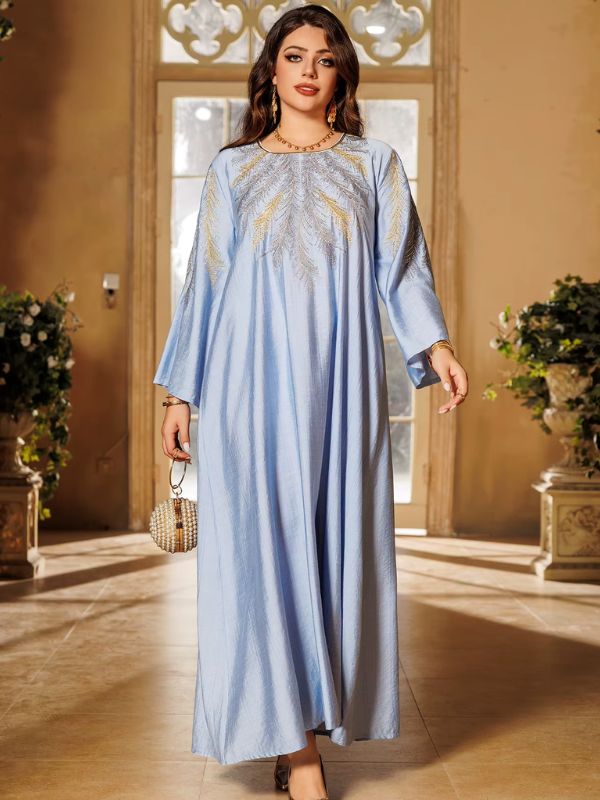 Une femme pose de face en djellaba ample bleu clair