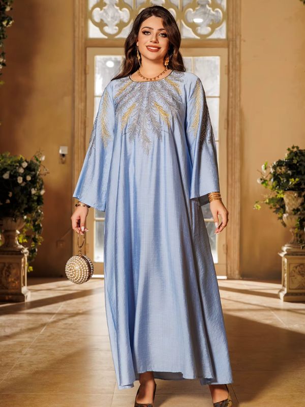 Une femme pose gracieusement en djellaba bleu clair brodée