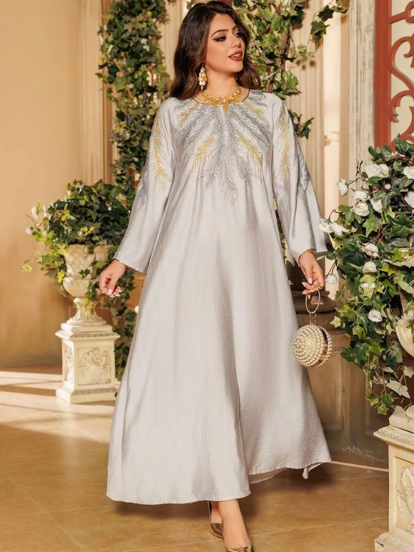 Une femme de profil porte une djellaba grise