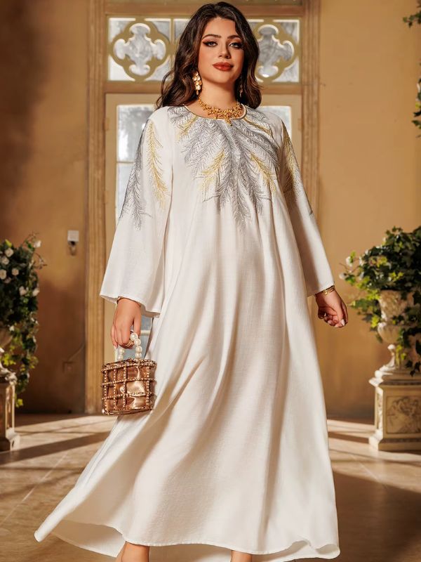 Une femme porte une djellaba de couleur grise avec un petit sac